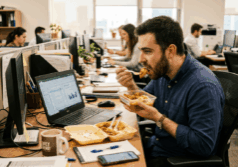man eats lunch at his office desk