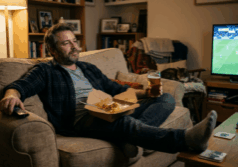man in his forties sits on a couch