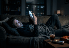 man lies on the couch late at night